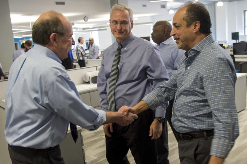 Gabriel Escobar, right, accepts congratulations from Philadelphia Inquirer Editor William K. Marimow after Stan Wischnowski, Philadelphia Media Network executive editor and senior vice president, center, announced that Escobar is being promoted to the new position of PMN editor and vice president. Michael Days, in background, becomes PMN editor for reader engagement. (Clem Murray/philly.com)